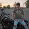 A man sitting on a Women's Ride Forever - Forever Free Tee, feeling free as he rides forever.