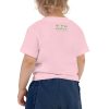 A little girl, filled with belief and determination, proudly wearing a 'Dream Believe Achieve' Unicorn T-shirt and blue shorts.