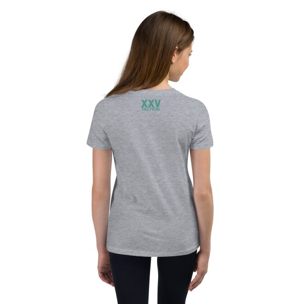 The back view of a girl wearing a Youth Love, Waves & Mermaids T-Shirt, standing near crashing waves.