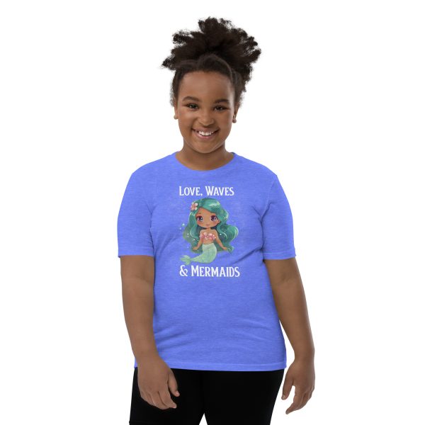 A youth wearing a Youth Love, Waves & Mermaids T-Shirt is transformed into a mermaid by the crashing waves.