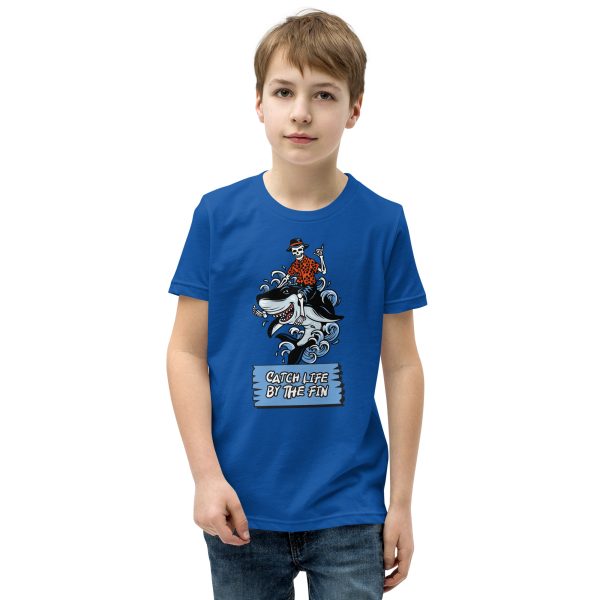 A youth wearing a Youth Catch Life by The Fin T-Shirt with an image of a boy riding a horse.